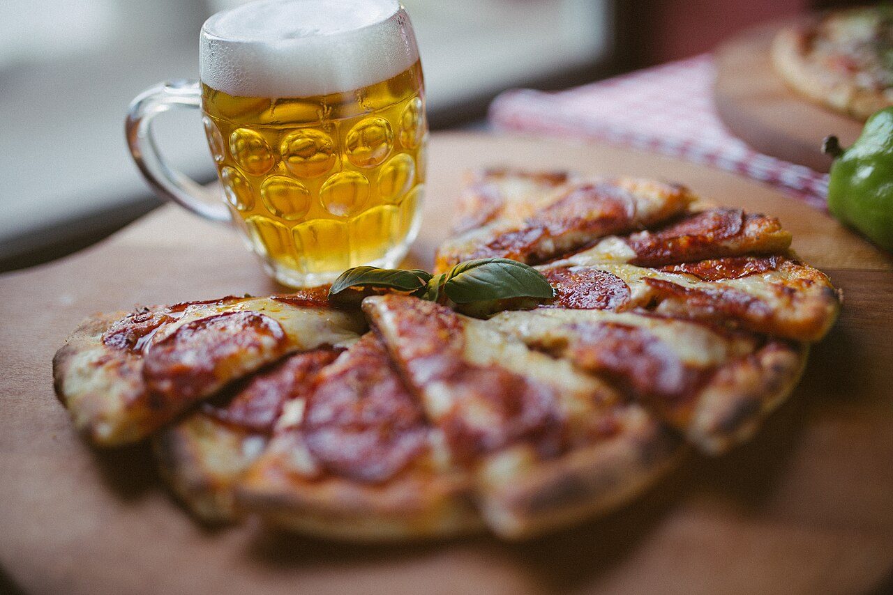 Pizza e birra servite al tavolo